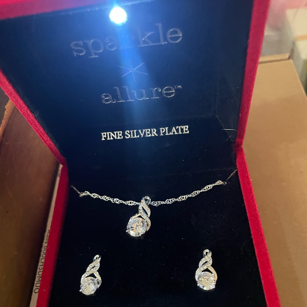 Beautiful earrings and necklace in a box with a light shining on set